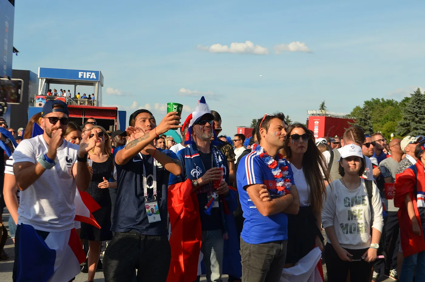 France supporters in blue wave tricolour flags in a packed stadium, evoking France's 1-0 Round of 16 win over Paraguay at World Cup 2026 in Philadelphia on July 4