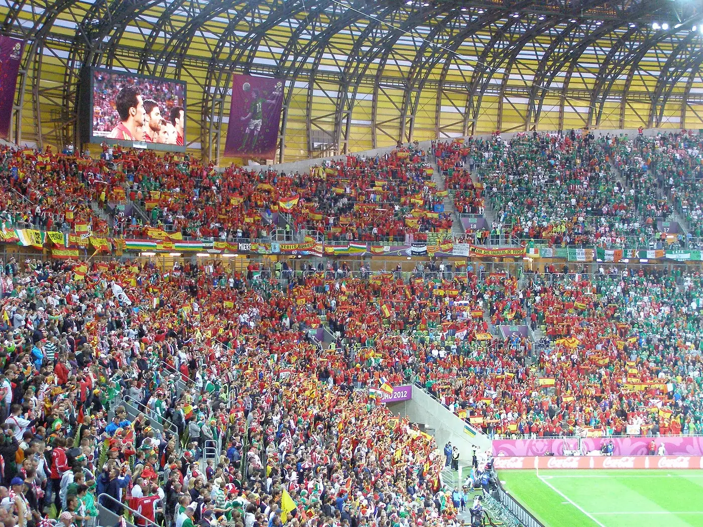Spain supporters in red fill the stands waving flags, evoking Spain's 1-0 win over Portugal in the World Cup 2026 Round of 16 in Arlington on July 6