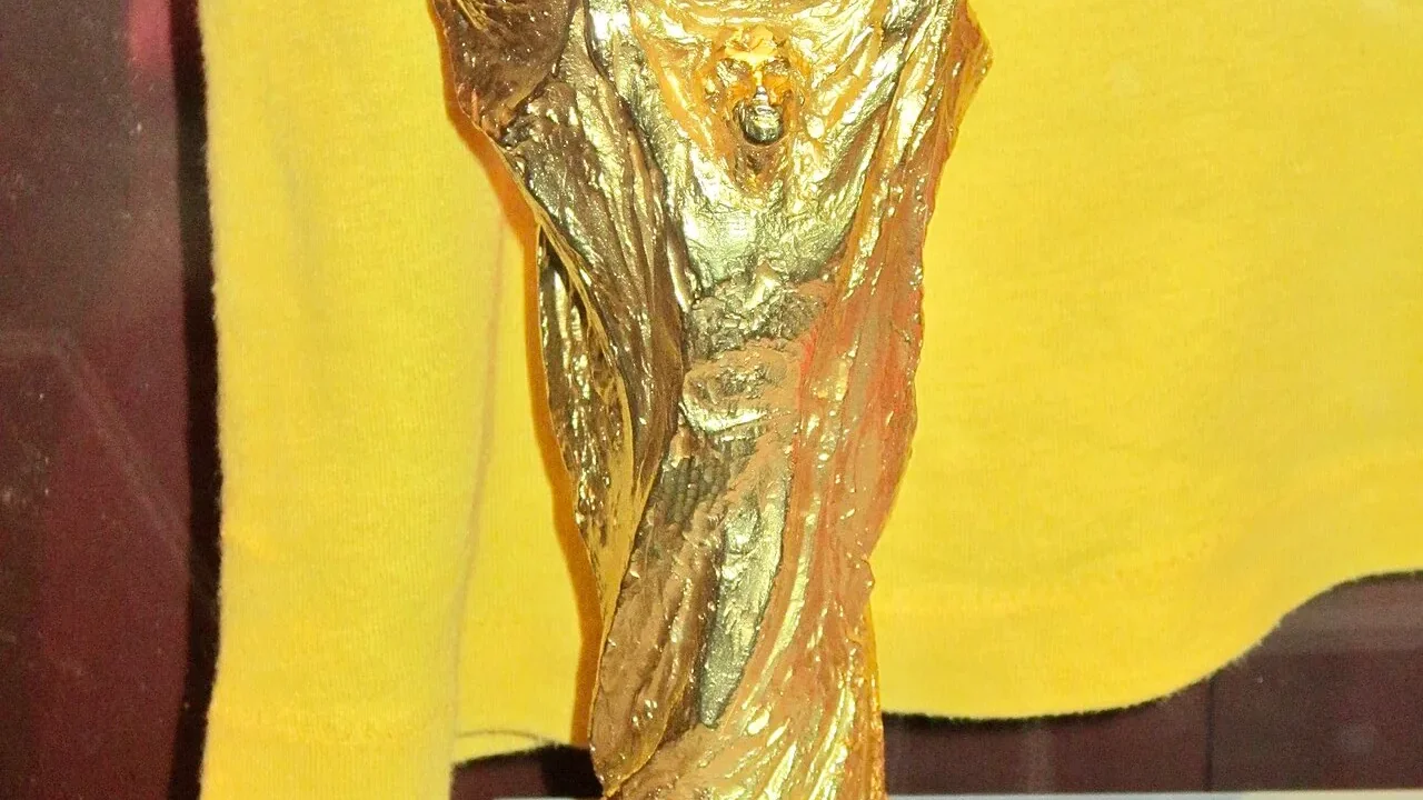 The FIFA World Cup trophy under stadium lights — Kylian Mbappé leads the all-time men's World Cup top scorers on 22 goals after passing Lionel Messi at the 2026 tournament